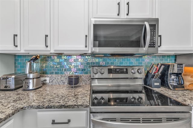 kitchen with tasteful backsplash, light stone countertops, white cabinets, and appliances with stainless steel finishes