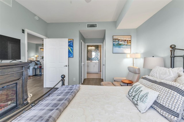 bedroom featuring wood-type flooring and connected bathroom