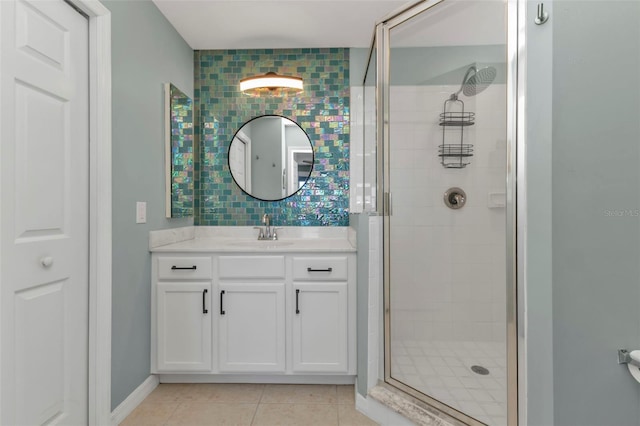 bathroom featuring tile patterned floors, a shower with shower door, and vanity