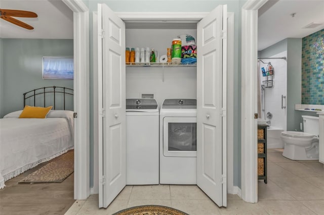 clothes washing area featuring ceiling fan, washing machine and clothes dryer, and light tile patterned floors