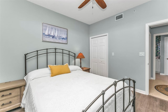 bedroom featuring dark wood-type flooring, ceiling fan, and a closet