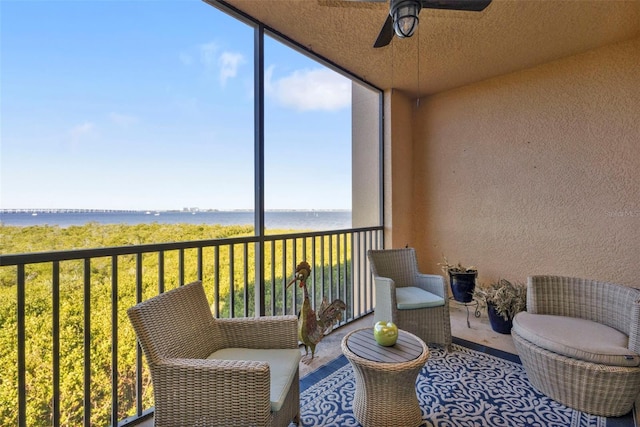 sunroom / solarium with a water view and ceiling fan