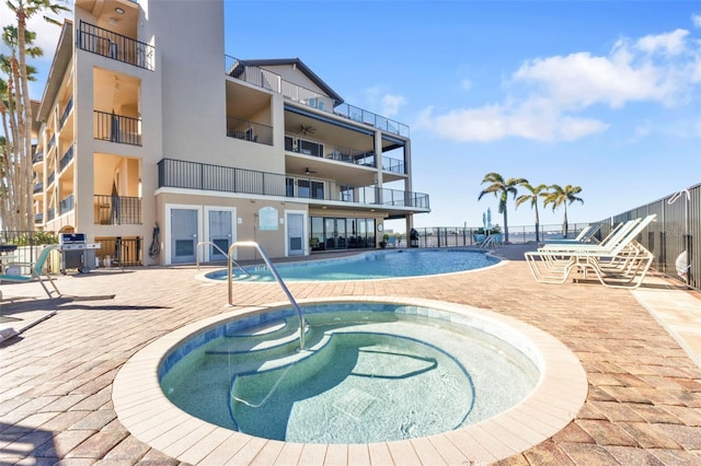 view of swimming pool featuring a grill and a hot tub