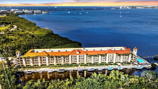 aerial view at dusk featuring a water view