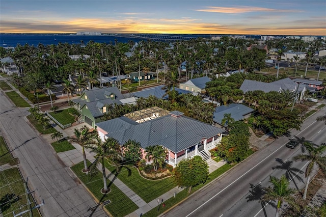 aerial view at dusk featuring a water view