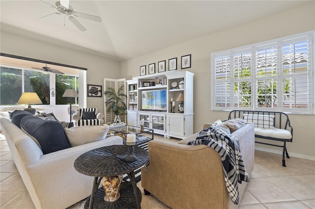 living room with ceiling fan, light tile patterned floors, and lofted ceiling