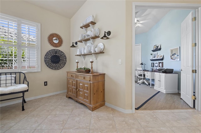 hallway with lofted ceiling and light tile patterned floors