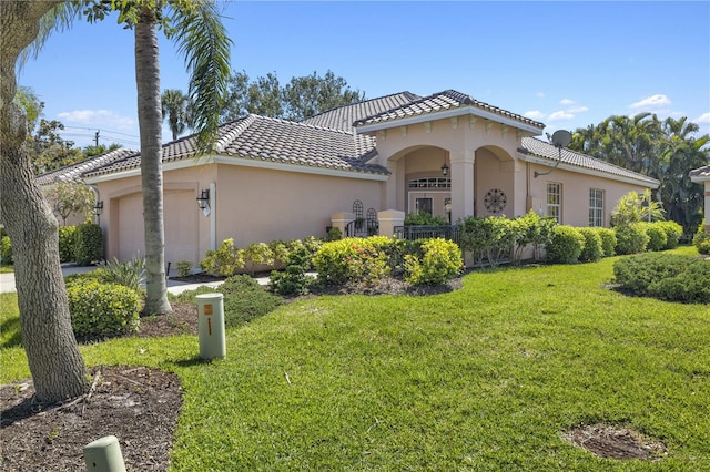 mediterranean / spanish house featuring a garage and a front lawn