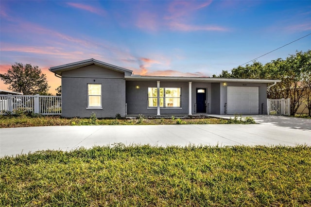 single story home with a lawn and a garage