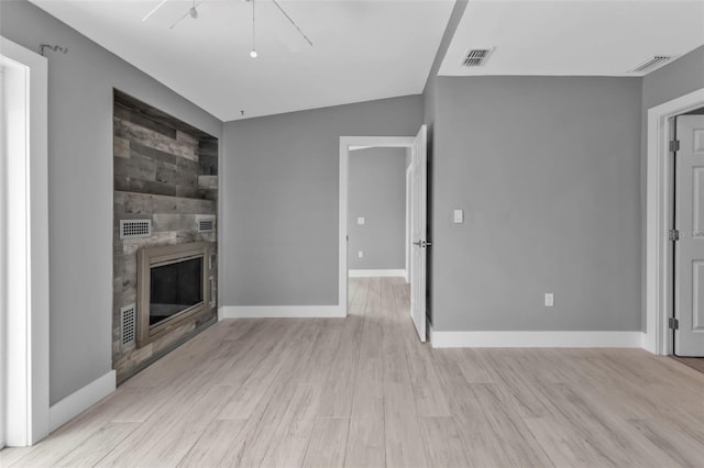 unfurnished living room featuring light hardwood / wood-style floors, ceiling fan, and wooden walls