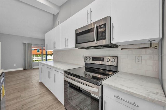 3112 Magnolia Way, Punta Gorda, FL 33950 - kitchen featuring tasteful backsplash, white cabinets, stainless steel appliances, light wood finished floors, and baseboards