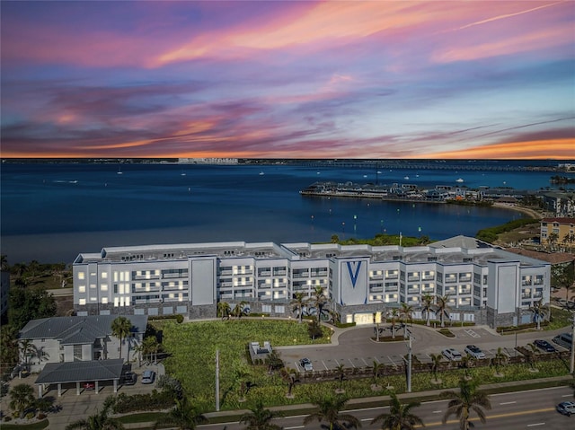 aerial view at dusk featuring a water view