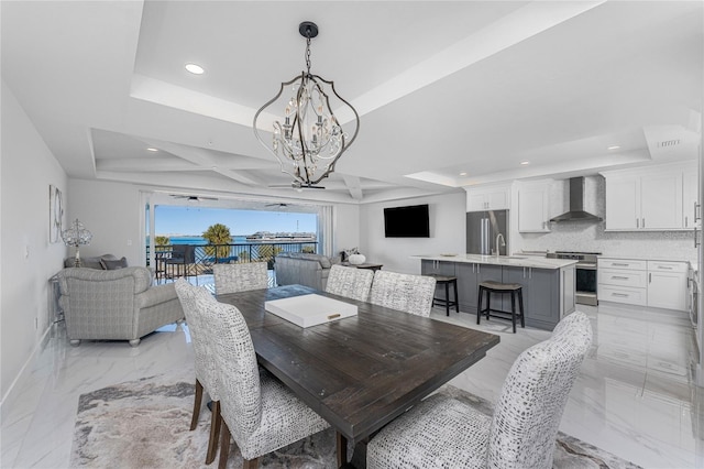 dining area featuring a tray ceiling and a chandelier