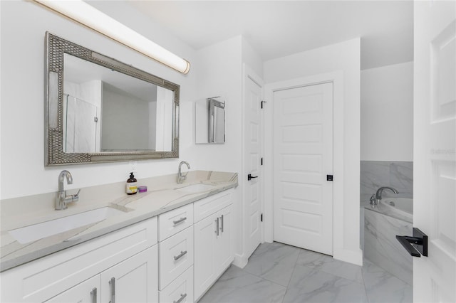 bathroom with vanity and tiled bath