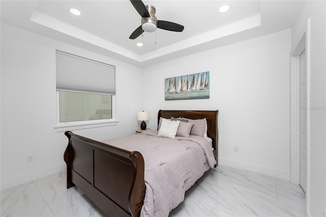 bedroom featuring a raised ceiling and ceiling fan