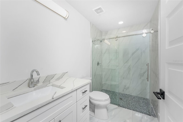 bathroom featuring vanity, a shower with door, and toilet