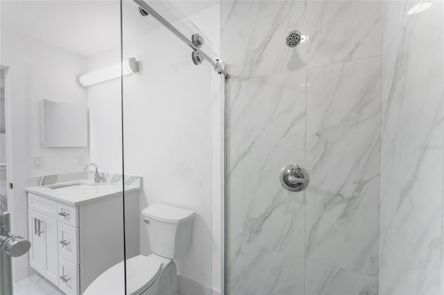 bathroom featuring vanity, toilet, and tiled shower