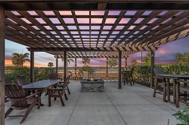 patio terrace at dusk with an outdoor fire pit and a pergola