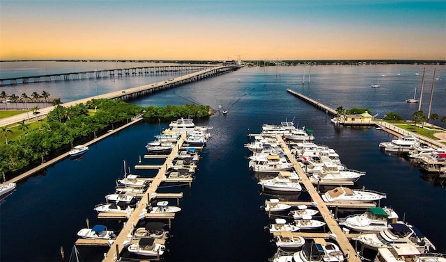 aerial view at dusk featuring a water view