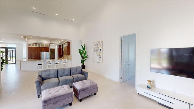 living room with a towering ceiling and sink