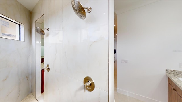 bathroom featuring a tile shower and vanity