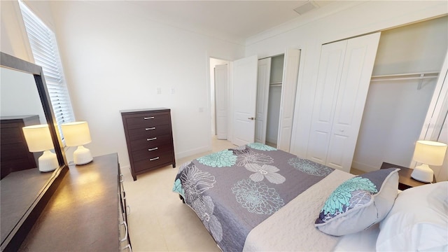 bedroom featuring crown molding and multiple closets