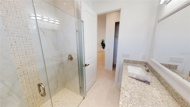 bathroom featuring tile patterned floors, vanity, and a shower with shower door