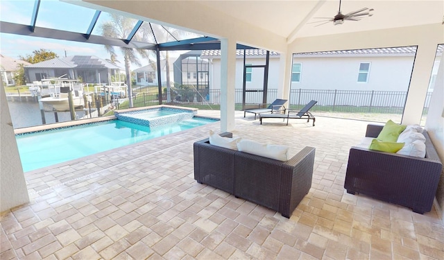 view of swimming pool with a patio area, an in ground hot tub, and glass enclosure