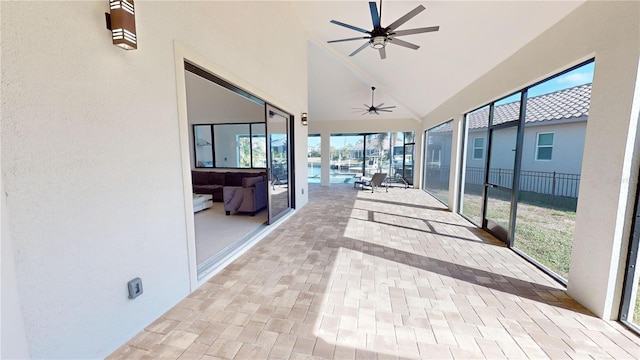 unfurnished sunroom featuring ceiling fan and vaulted ceiling