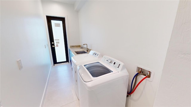 laundry room featuring light tile patterned floors, separate washer and dryer, and sink