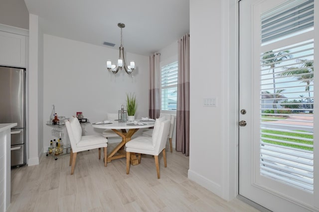 dining area featuring light hardwood / wood-style flooring and an inviting chandelier