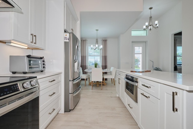 kitchen with white cabinets, a notable chandelier, decorative light fixtures, and appliances with stainless steel finishes