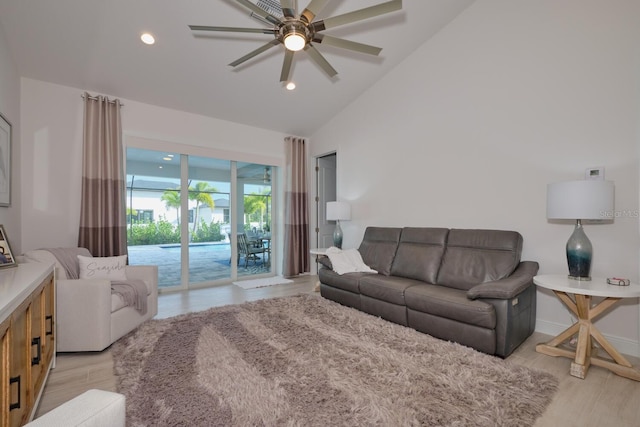 living room with ceiling fan, light hardwood / wood-style floors, and high vaulted ceiling