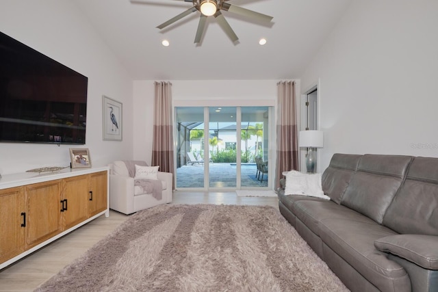 living room featuring ceiling fan, light hardwood / wood-style floors, and lofted ceiling