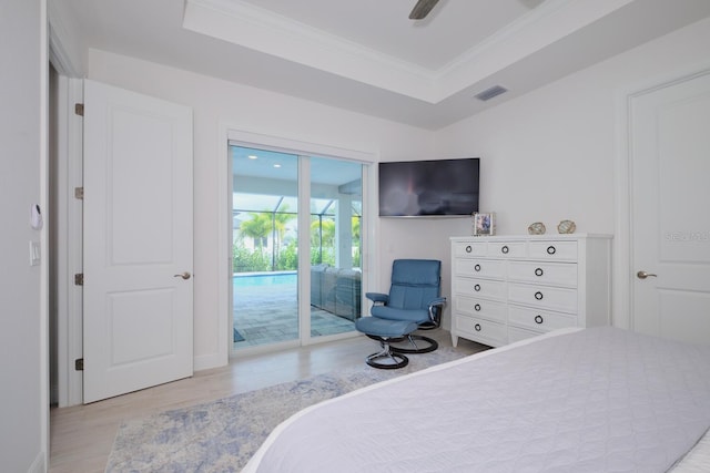 bedroom featuring crown molding, ceiling fan, access to exterior, light wood-type flooring, and a tray ceiling