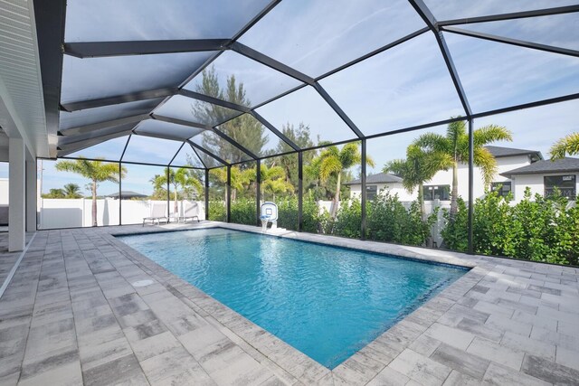 view of pool with glass enclosure and a patio area