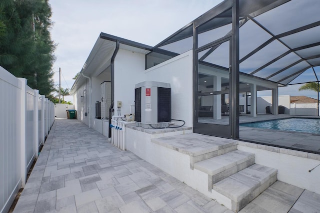 view of patio featuring a fenced in pool and glass enclosure