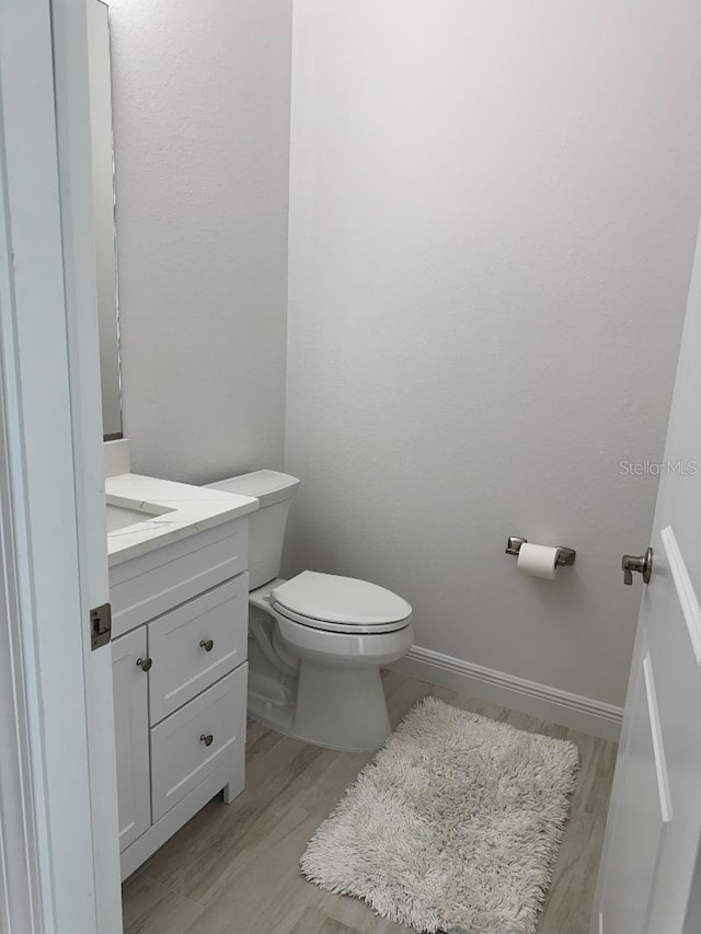 bathroom featuring hardwood / wood-style floors, vanity, and toilet