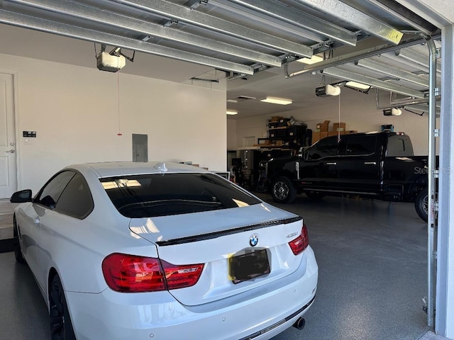 garage with electric panel and a garage door opener