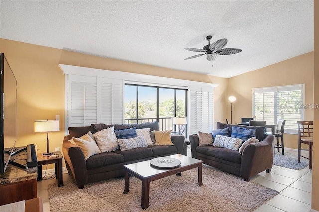 tiled living room featuring a textured ceiling, ceiling fan, and lofted ceiling