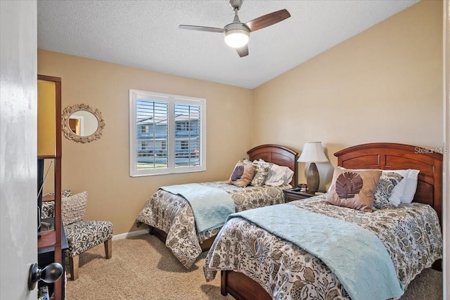 bedroom with ceiling fan, carpet floors, and a textured ceiling