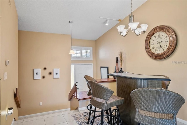 interior space with a chandelier, vaulted ceiling, hanging light fixtures, and light tile patterned floors