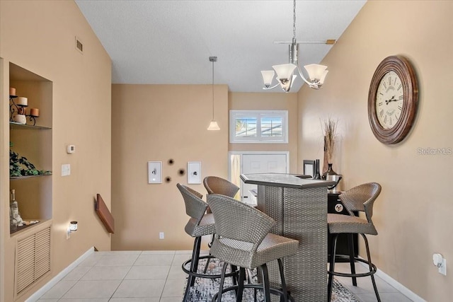 dining area with light tile patterned floors, a chandelier, and vaulted ceiling