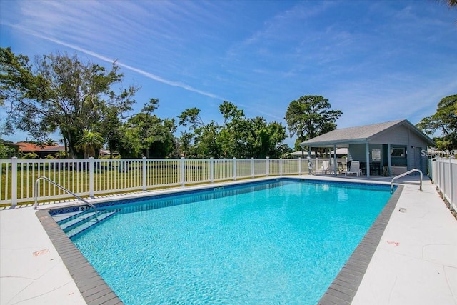 view of swimming pool featuring an outdoor structure and a patio area