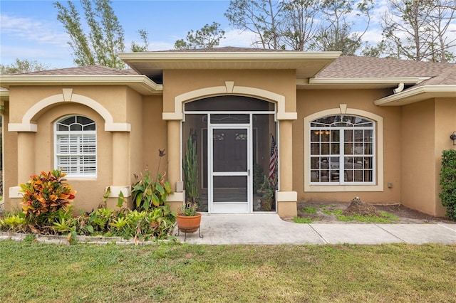 entrance to property featuring a lawn