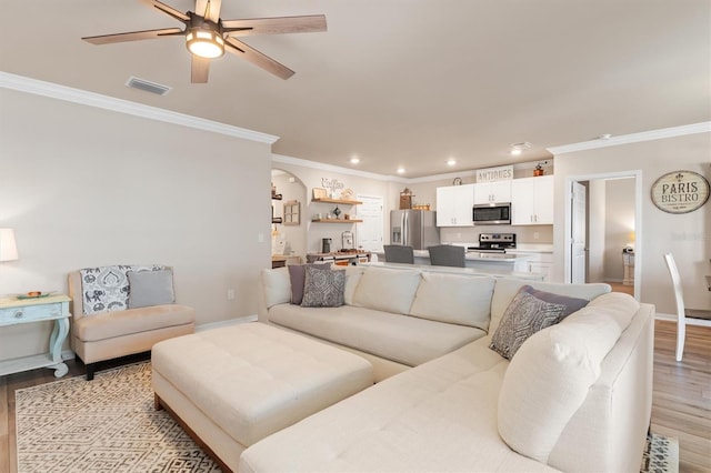 living room featuring ceiling fan, light hardwood / wood-style flooring, and crown molding