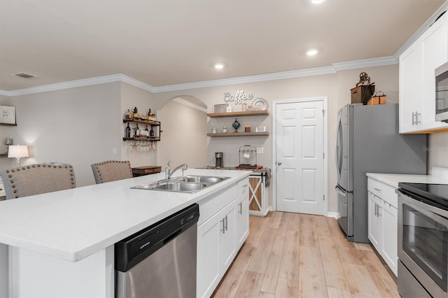 kitchen with appliances with stainless steel finishes, sink, a center island with sink, light hardwood / wood-style flooring, and white cabinetry