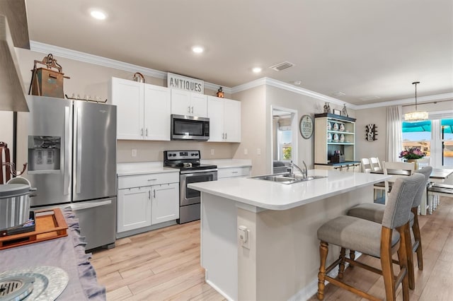 kitchen featuring pendant lighting, sink, an island with sink, appliances with stainless steel finishes, and white cabinetry