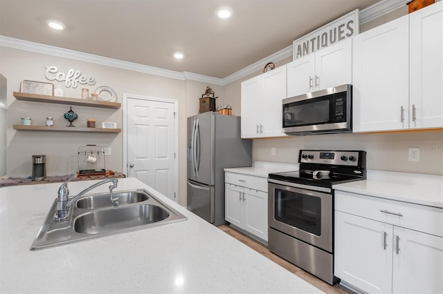 kitchen featuring white cabinetry, sink, appliances with stainless steel finishes, and ornamental molding