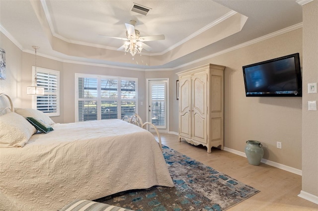 bedroom featuring a tray ceiling, ceiling fan, light hardwood / wood-style floors, and access to outside